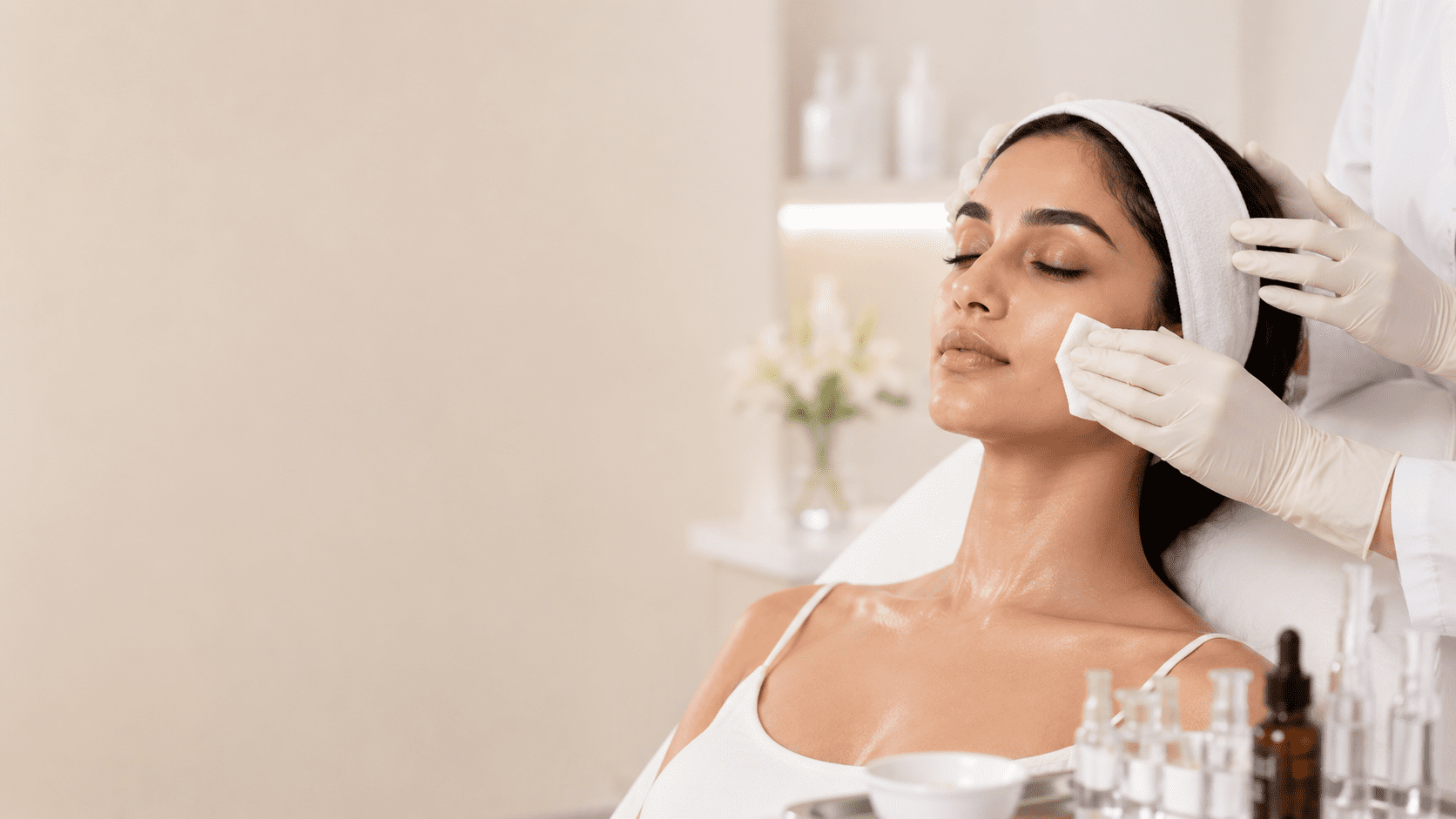 Dermatologist neutralising acid peel and applying barrier-protective soothing agent to patient's skin